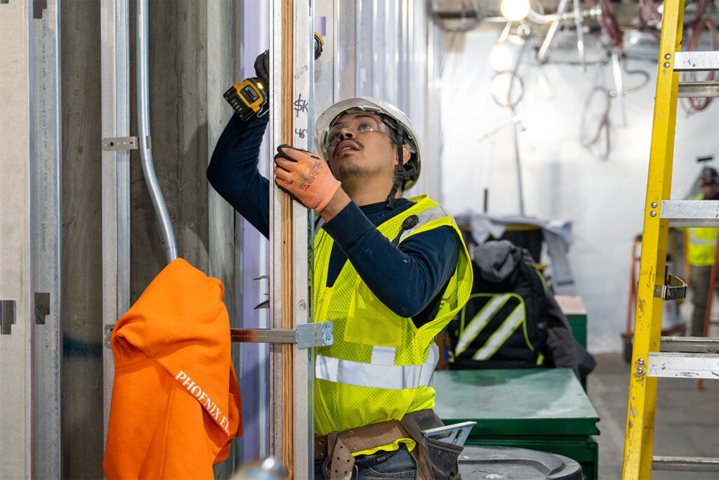 Escobar Construction Inc worker nailing in metal frames